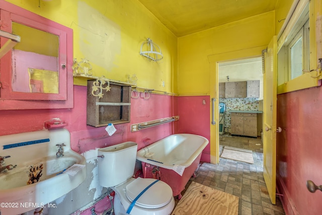 bathroom with sink, toilet, and a tub