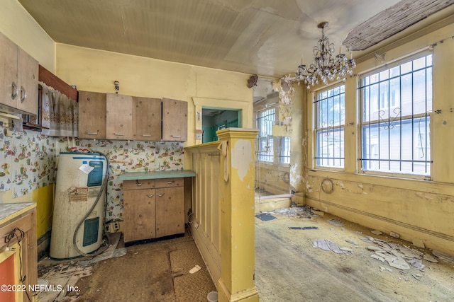 kitchen with pendant lighting, electric water heater, and an inviting chandelier