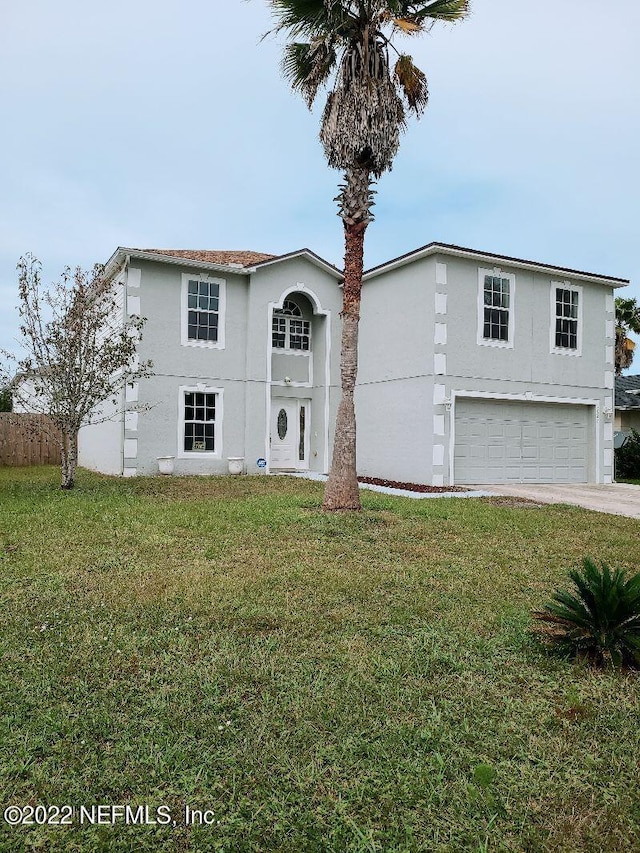 view of property with a front lawn and a garage