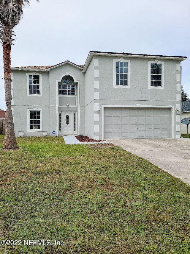 front of property with a garage and a front lawn