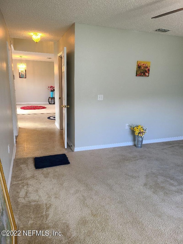 hall with carpet and a textured ceiling