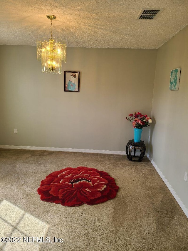 interior space featuring carpet flooring, a textured ceiling, and a chandelier