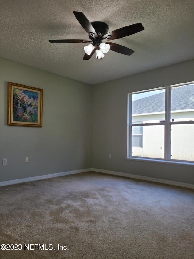 carpeted empty room featuring a textured ceiling and ceiling fan