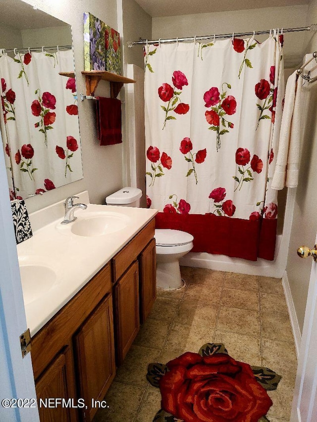 full bathroom featuring toilet, vanity, shower / tub combo with curtain, and tile patterned flooring