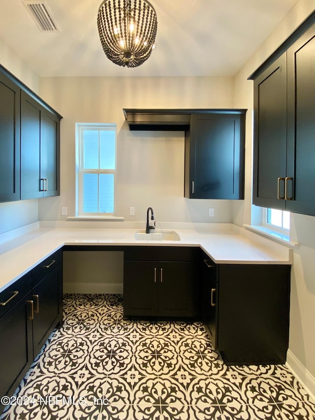 kitchen featuring sink, light tile patterned floors, and a notable chandelier