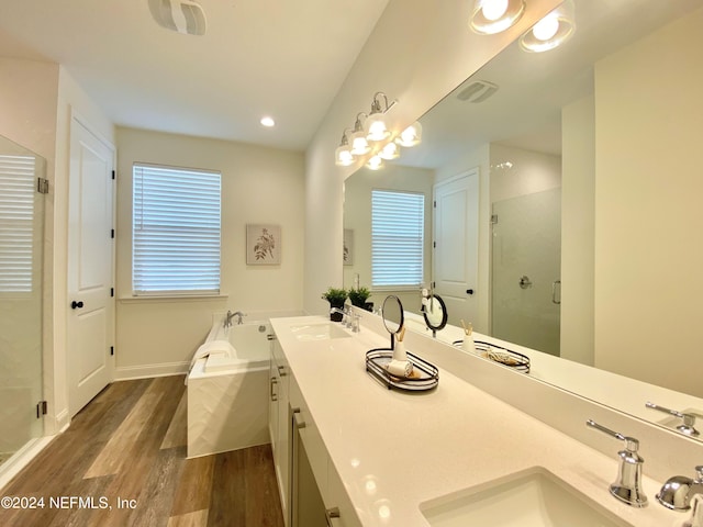 bathroom with a healthy amount of sunlight, vanity, independent shower and bath, and hardwood / wood-style floors