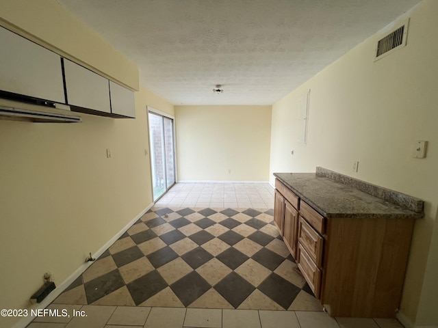 kitchen with light tile patterned floors and a textured ceiling