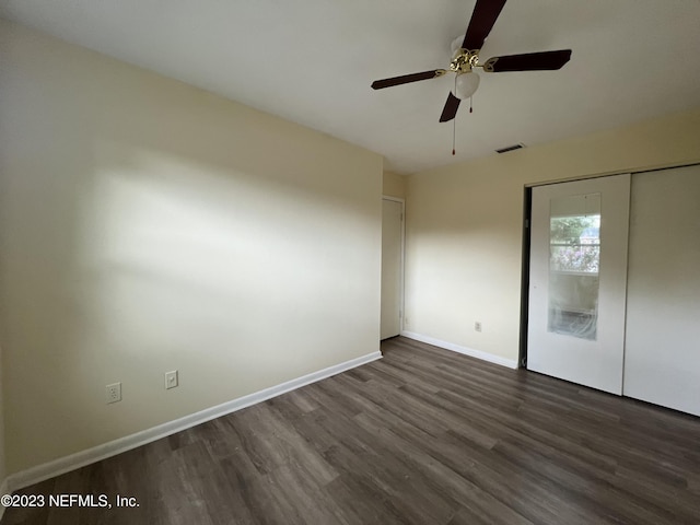 unfurnished bedroom featuring ceiling fan and dark hardwood / wood-style flooring