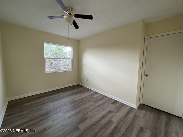 empty room featuring dark hardwood / wood-style flooring and ceiling fan