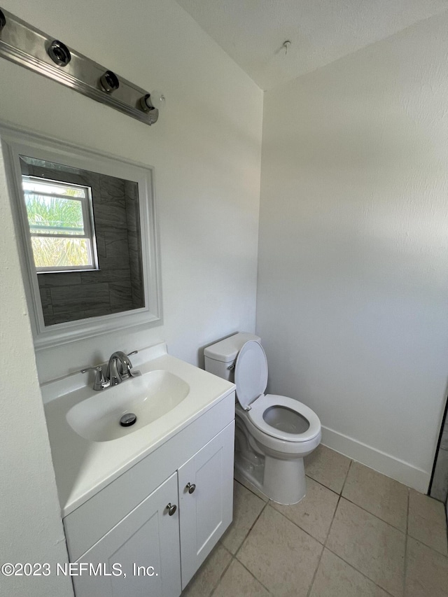 bathroom with tile patterned flooring, vanity, and toilet