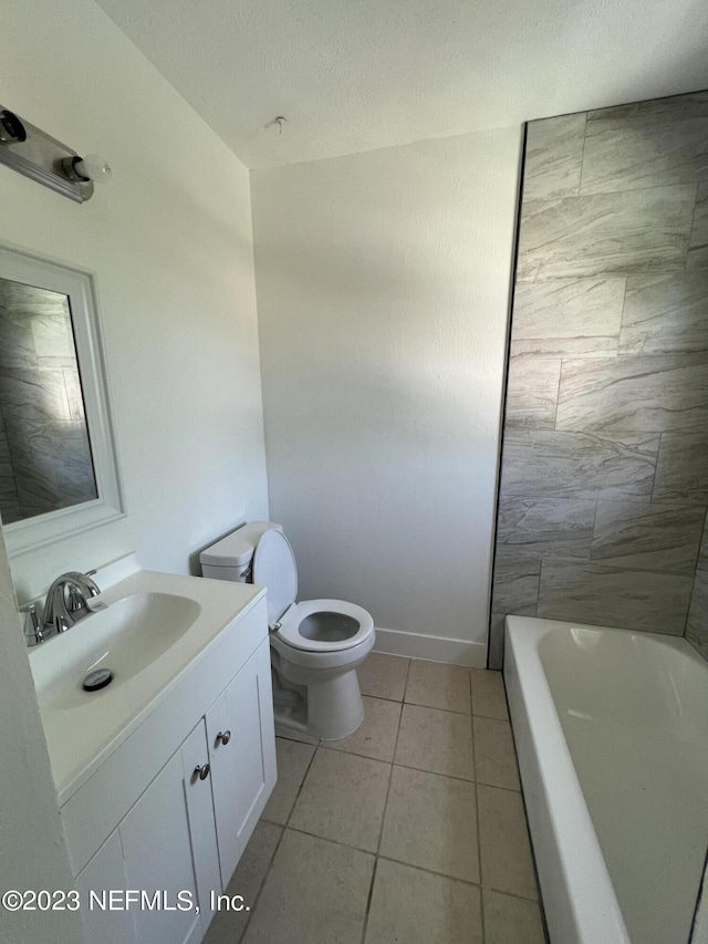 bathroom with tile patterned flooring, vanity, a textured ceiling, and toilet