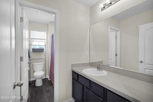 bathroom featuring vanity, wood-type flooring, and toilet