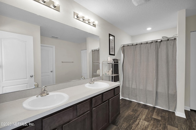 bathroom featuring vanity, hardwood / wood-style flooring, and a textured ceiling