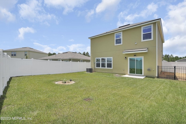 back of property with a lawn and central air condition unit