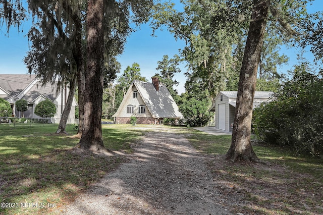 view of front of home featuring a front lawn and an outbuilding