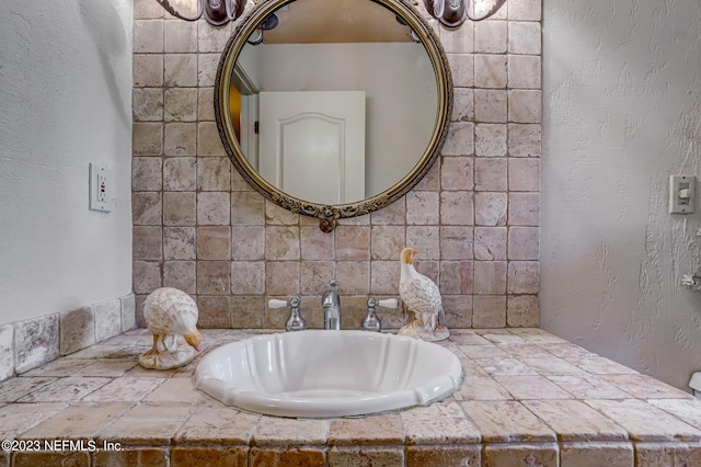 bathroom with sink and tasteful backsplash