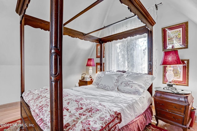 bedroom featuring light hardwood / wood-style flooring and lofted ceiling