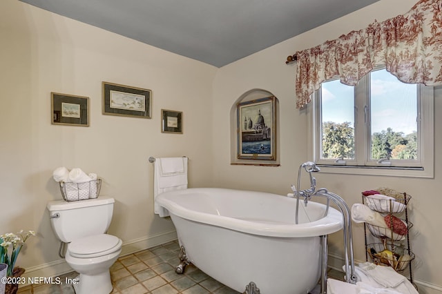 bathroom with tile patterned flooring, toilet, and a tub