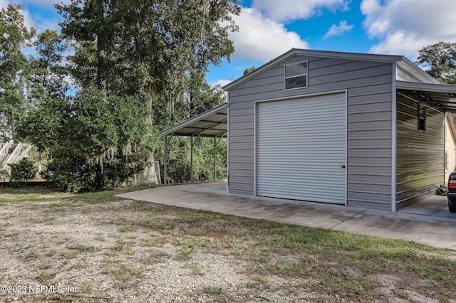 garage with wood walls and a carport