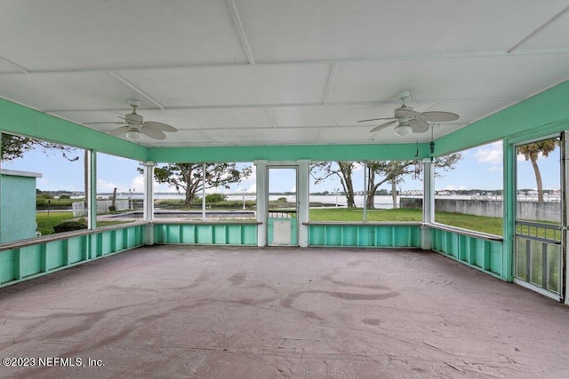 unfurnished sunroom featuring ceiling fan, plenty of natural light, and a water view