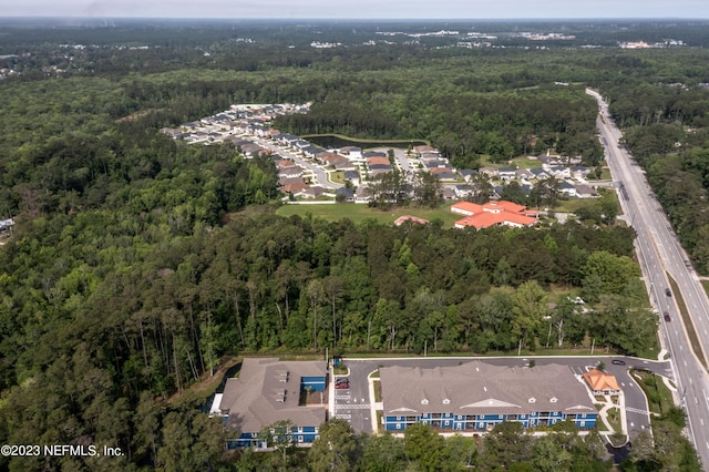 drone / aerial view with a residential view and a wooded view