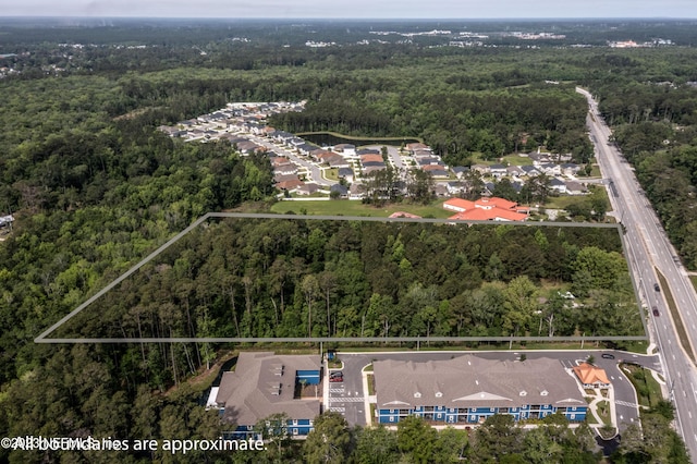 birds eye view of property featuring a residential view and a wooded view