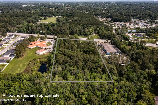 drone / aerial view featuring a forest view