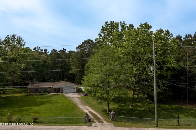 view of front of house with driveway, fence, and a front yard