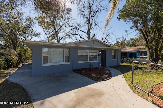 view of front facade with concrete block siding and a front lawn