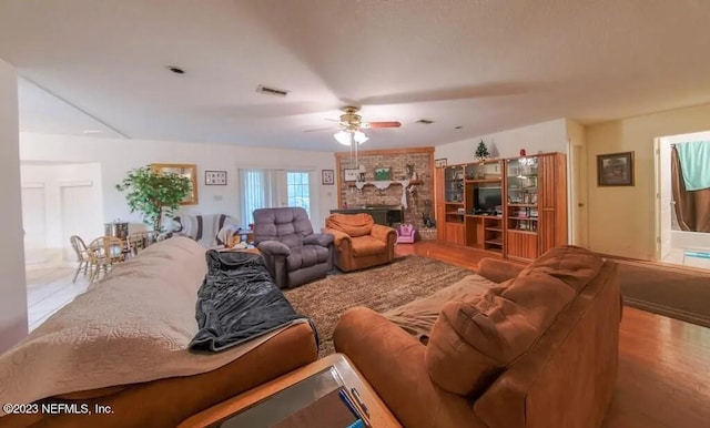 living room featuring hardwood / wood-style flooring, a fireplace, and ceiling fan