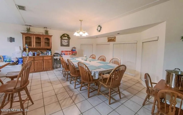 tiled dining area featuring an inviting chandelier