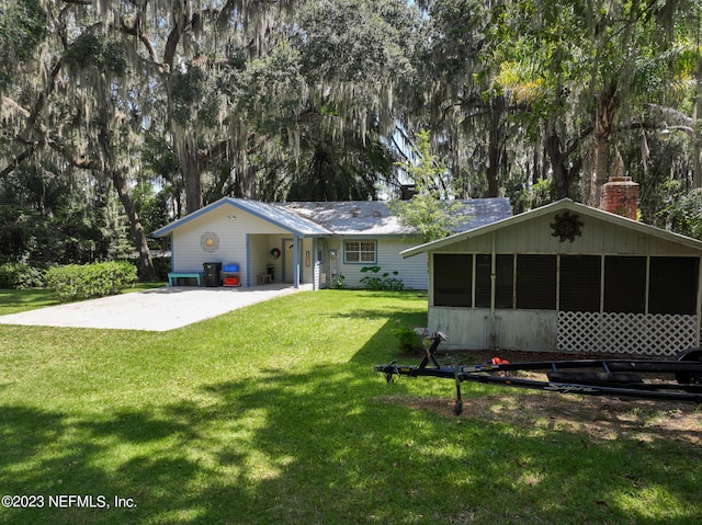 back of house featuring a yard and a sunroom