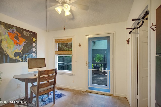 office area with a textured ceiling, ceiling fan, and tile patterned floors