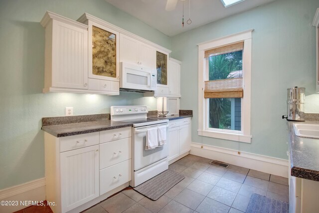 kitchen with light tile patterned flooring, ceiling fan, white appliances, and white cabinets