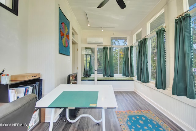 recreation room with ceiling fan, a wall mounted air conditioner, hardwood / wood-style flooring, and track lighting