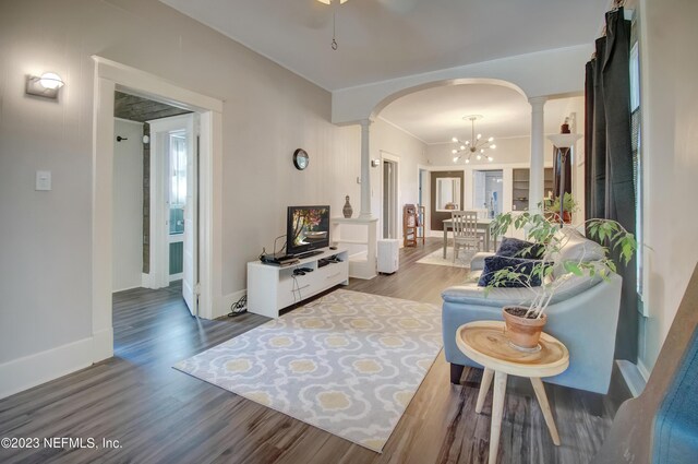 living room with decorative columns, wood-type flooring, and a chandelier