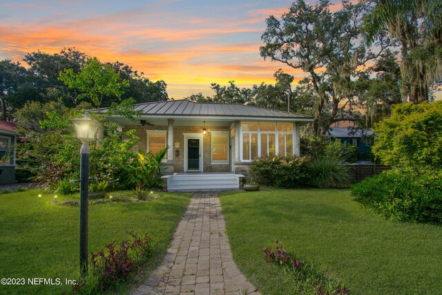 view of front of property featuring covered porch and a lawn