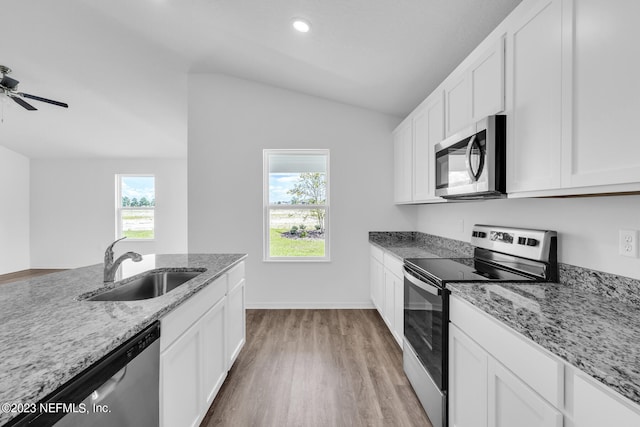 kitchen featuring white cabinetry, sink, light stone countertops, and appliances with stainless steel finishes