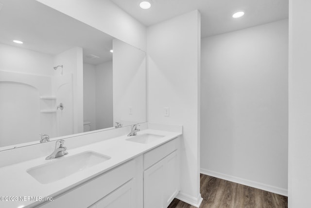 full bathroom featuring toilet, baseboards, a sink, and wood finished floors