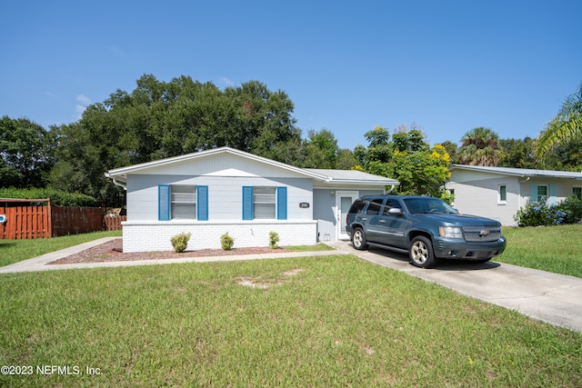 ranch-style home featuring driveway, a front lawn, and brick siding