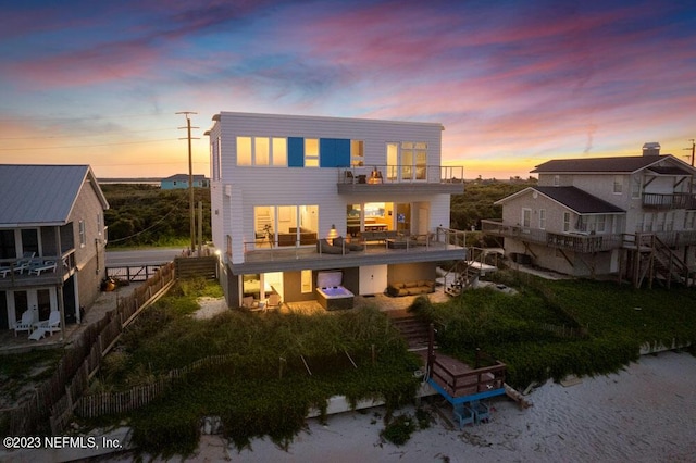 back house at dusk with a balcony