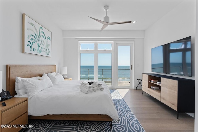 bedroom featuring hardwood / wood-style floors, ceiling fan, access to outside, and multiple windows