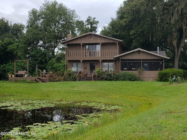 back of property featuring a lawn and a balcony