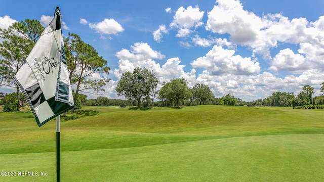 view of home's community with golf course view and a lawn