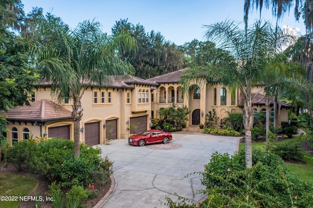 mediterranean / spanish-style house with a garage and a balcony