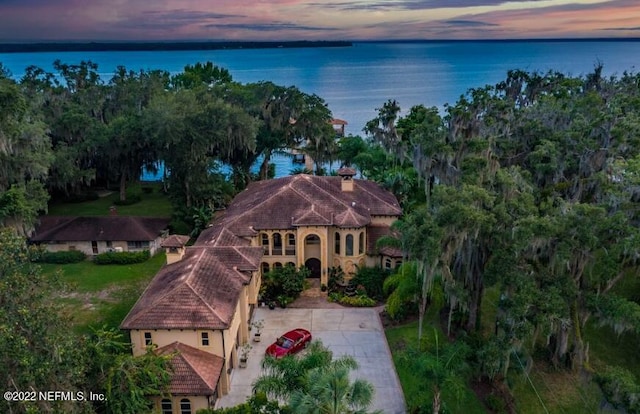 aerial view at dusk featuring a water view