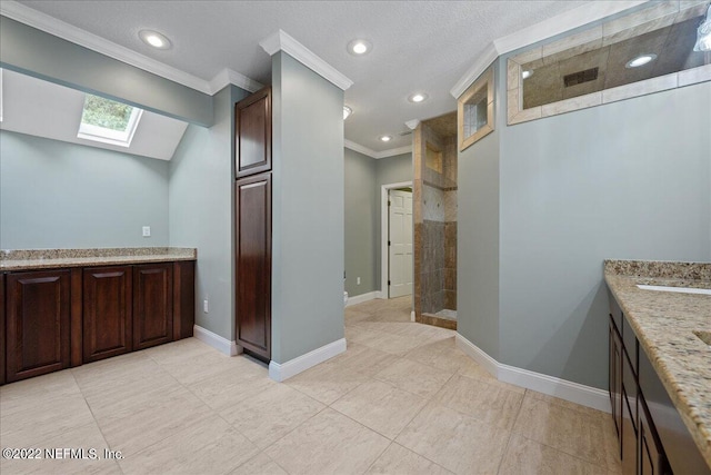 bathroom featuring a skylight, walk in shower, tile patterned floors, crown molding, and vanity