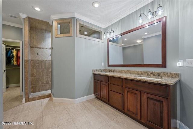 bathroom with vanity, a textured ceiling, tile patterned floors, walk in shower, and crown molding