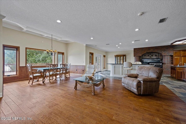 living room featuring a textured ceiling, wood walls, and hardwood / wood-style flooring