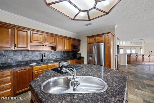 kitchen featuring sink, a textured ceiling, stainless steel appliances, a center island, and crown molding